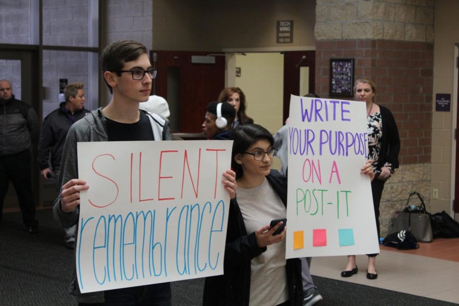 Students hold signs asking for student participation in the walk out. Many students complained that others werent silent while outside. 