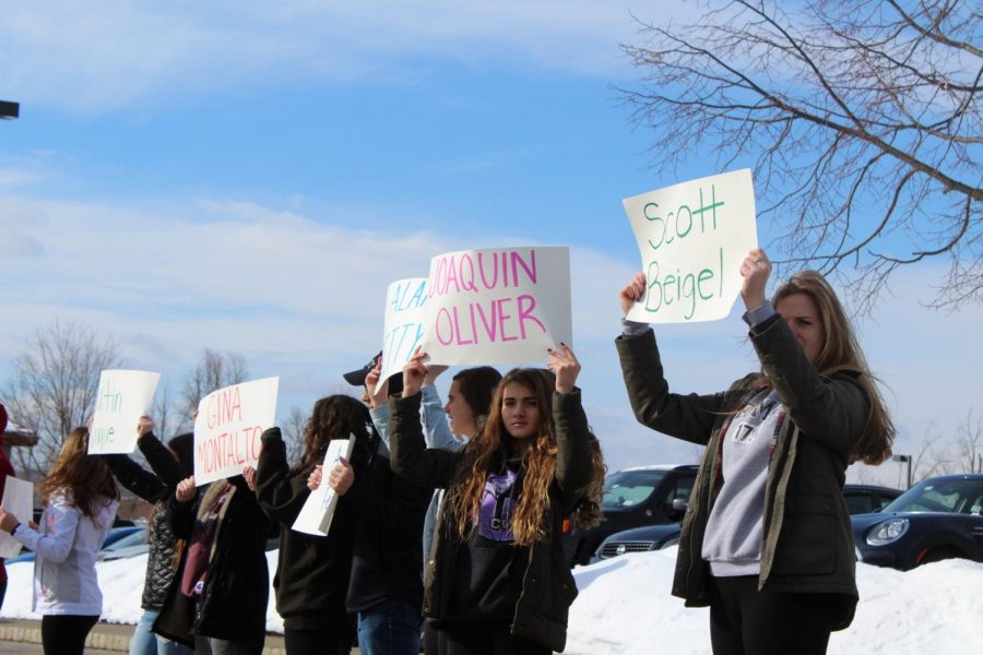 Students hold up signs honoring  victims of the Marjoy Stoneman Douglas High School   