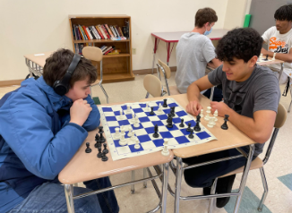Two students practice playing chess after school 