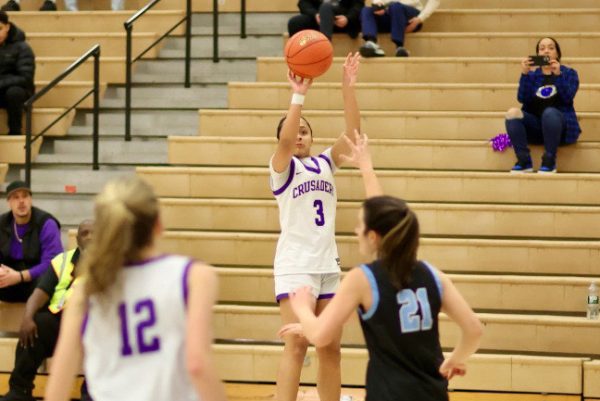 Madison Fileen leaps from the ground as she takes the record-breaking shot that put her at 1,000 career points.

Photographer: William Dimmit