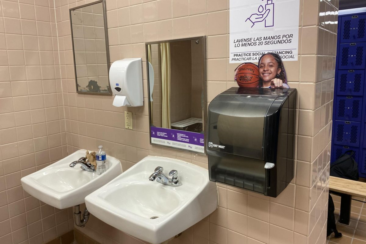 A photo of Madison Fileen peeks over the paper towel dispenser in the girls' locker room. The same photo of her is also on display on the locker room's announcement board.