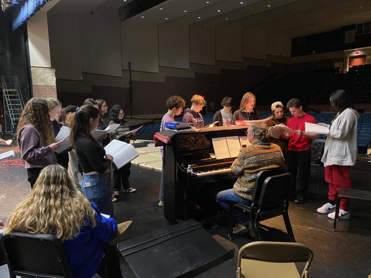 Dr. Crone leads the Drama Club in rehearsing the music for "The Secret Garden", the 2025 spring musical. The Drama Club performs a play in the fall and a musical in the spring, alongside smaller performances such as the Cabaret.